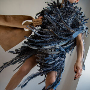 Unique handbag crafted from repurposed sofa leather, featuring natural texture and rich patina, captured in a creative composition by photographer Sandra Luks.